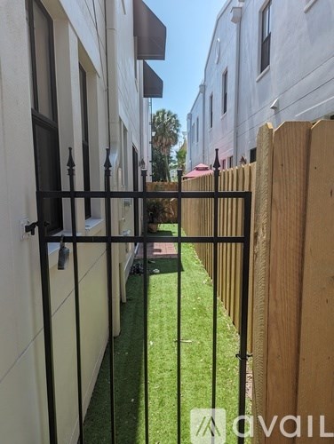 A black gate is in front of a white building.