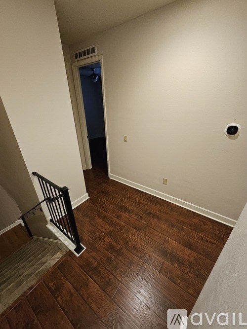 A hallway with a blue door and a wooden floor.