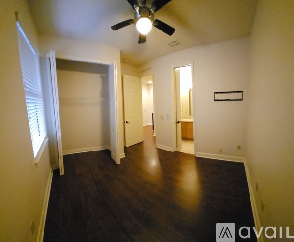 A room with a ceiling fan and wooden flooring.