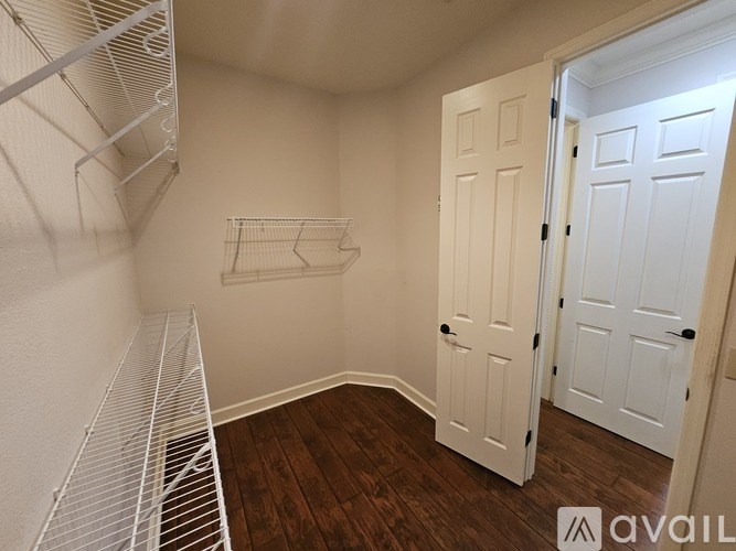 A white closet with a shelf and two doors.