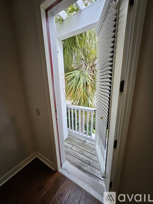 A white door with a window in the middle leading to a balcony.
