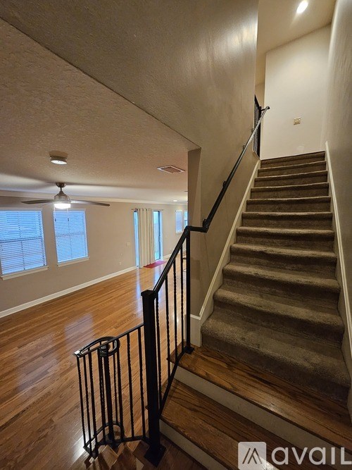 A staircase with a black railing leads up to a window.