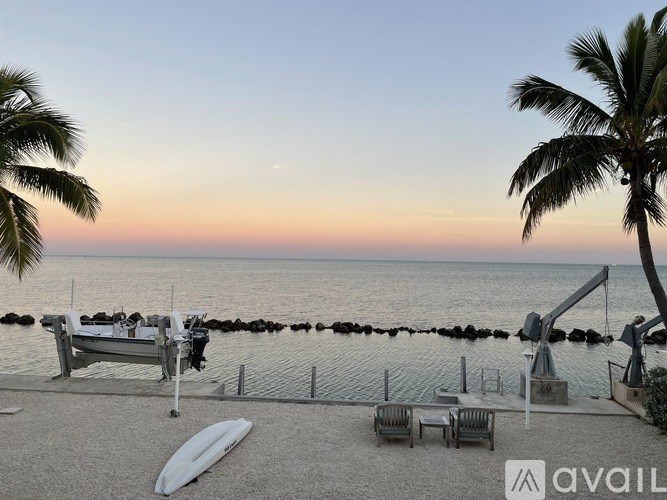 A beach scene with a sunset and palm trees.