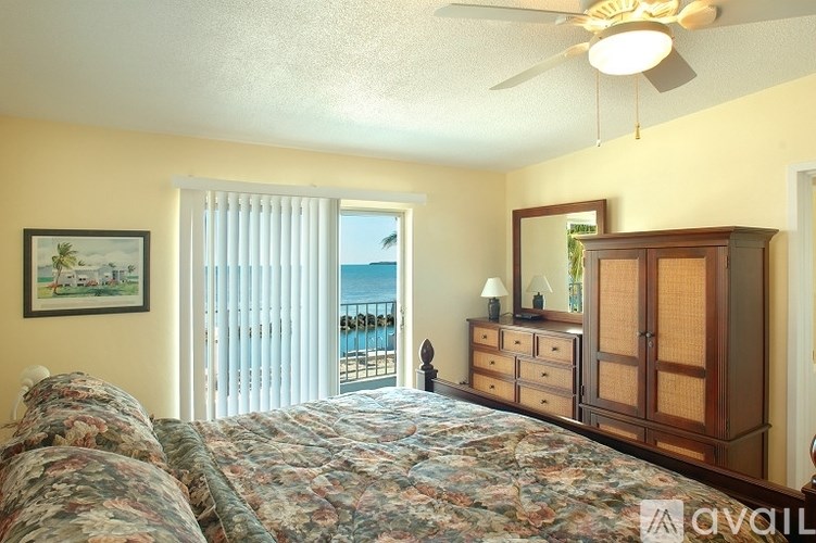 A bedroom with a large bed and a view of the ocean through the window.