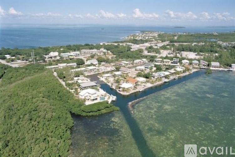 A bird's eye view of a coastal town with a body of water separating the land from the town.