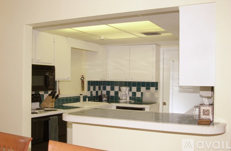 A kitchen with white cabinets and a black oven.