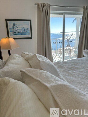 A bedroom with a large bed and a view of the ocean.