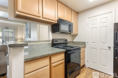 A kitchen with wooden cabinets and a granite countertop.