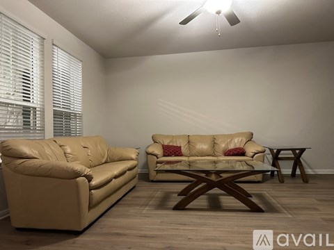 A living room with a tan couch and a tan leather couch.