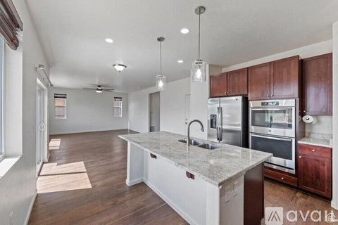 A kitchen with a marble countertop and stainless steel appliances.