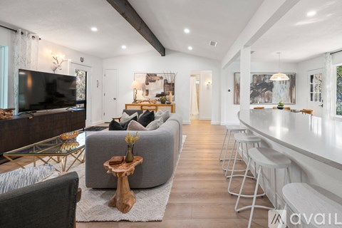 A modern living room with a grey sofa and a glass coffee table.