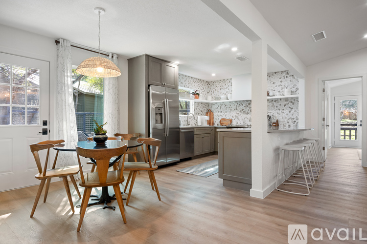 A modern kitchen with a dining table and chairs.