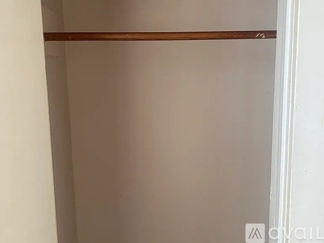 A white wall with a brown shelf on top.