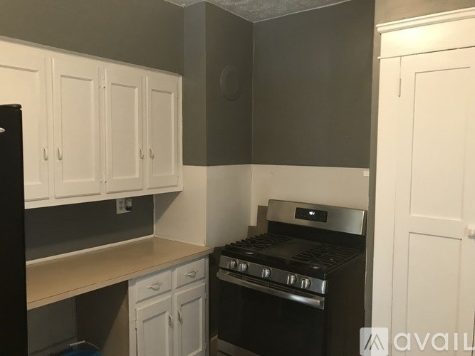 A kitchen with white cabinets and a black oven.