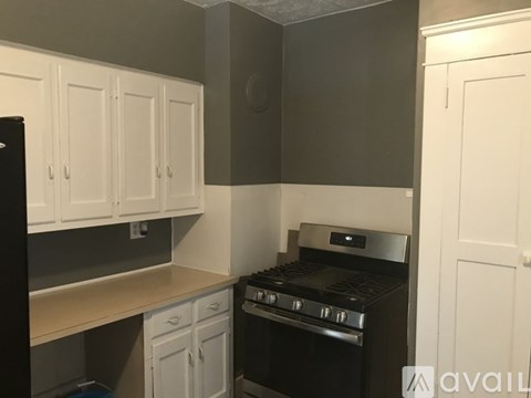 A kitchen with white cabinets and a black oven.