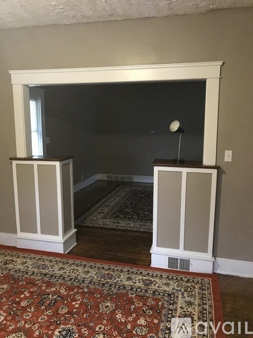 A room with a rug and a fireplace.
