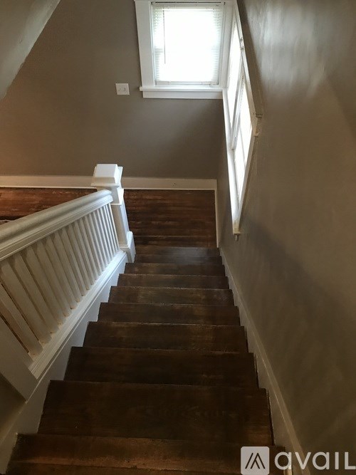 A staircase with wooden steps and white railings.