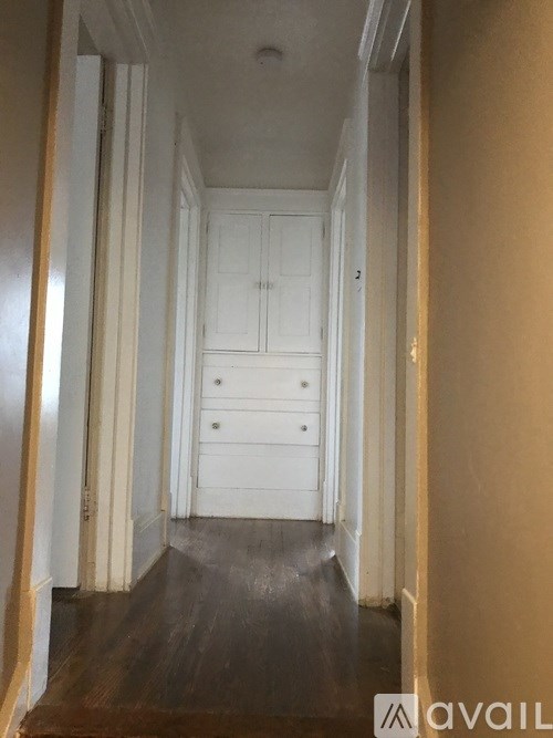 A hallway with white doors and drawers.