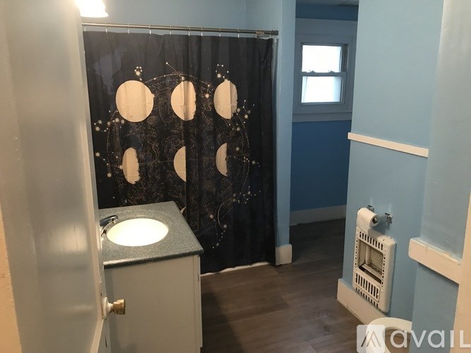A bathroom with a black shower curtain and a white sink.