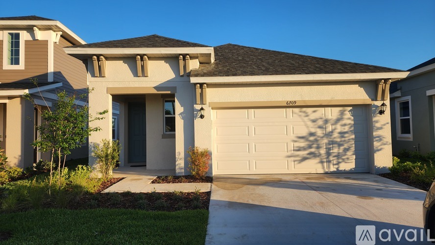 A house with a garage and a driveway is available for purchase.