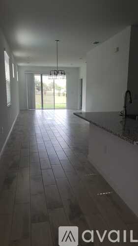 A kitchen with a black counter top and a tiled floor.