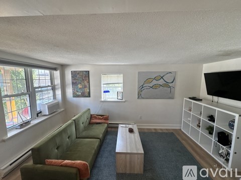 A living room with a green couch and a wooden coffee table.