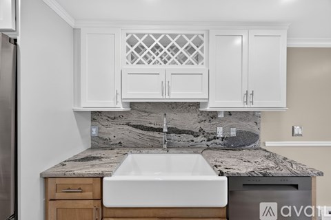 A kitchen with white cabinets and appliances.