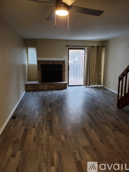 A living room with a fireplace and wood flooring.