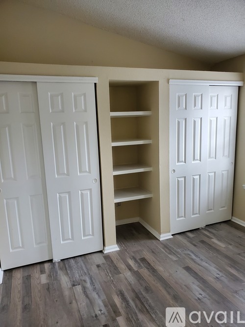 A room with a white door and shelves.