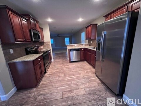 A kitchen with wooden cabinets and a tile floor.