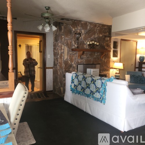 A bedroom with a bed, a ceiling fan, and a rug.