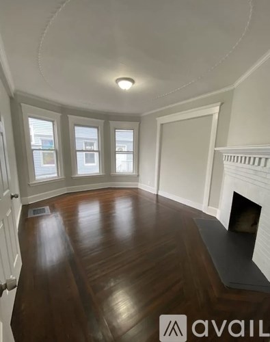 A room with a fireplace and wood flooring.