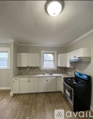 A kitchen with white cabinets and a black dishwasher.