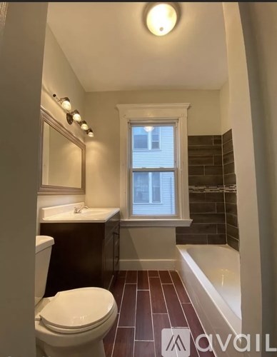 A bathroom with a toilet, sink, and tub.