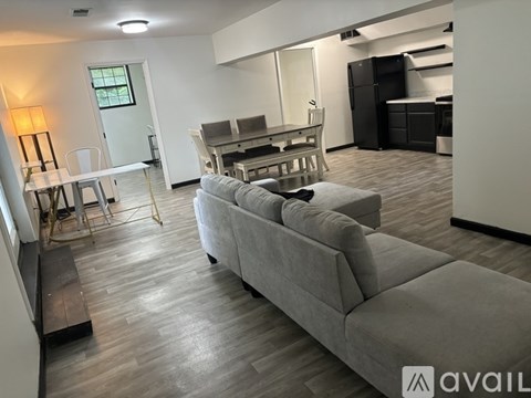 A living room with a grey couch and a dining table.