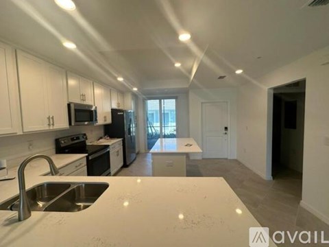 A kitchen with white cabinets and a stainless steel sink.