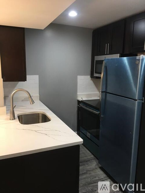 A kitchen with a sink and a refrigerator.