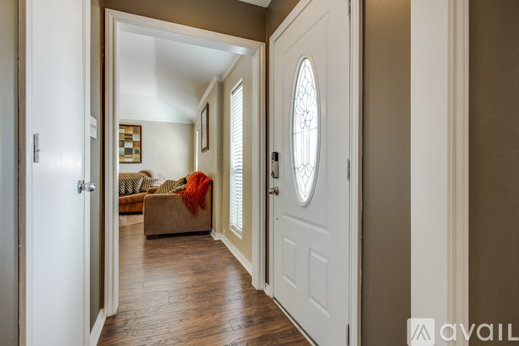 A hallway with a white door and a window with blinds.