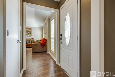 A hallway with a white door and a window with blinds.