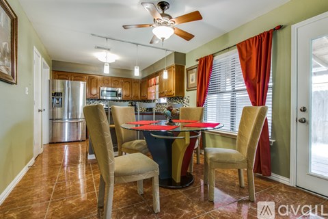 A dining room with a table and chairs.