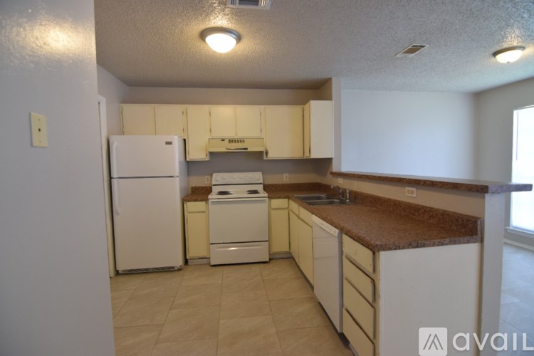A kitchen with white appliances and a brown countertop.