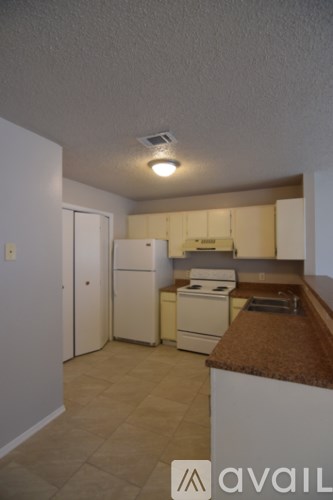 A kitchen with a white refrigerator and a brown counter.