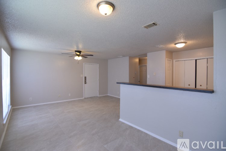 A spacious room with a ceiling fan and a row of closets.