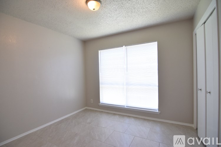 A room with a window and a door is available for rent.