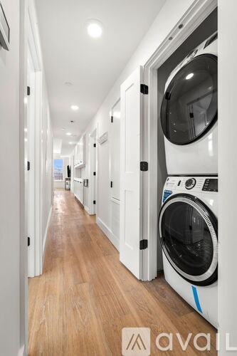 A long hallway with a washing machine on the right.