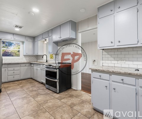 A kitchen with white cabinets and a black dishwasher.
