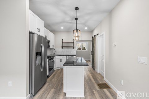 A modern kitchen with a refrigerator, oven, and a central island.