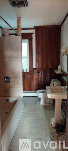 A bathroom with wooden walls and a white sink.
