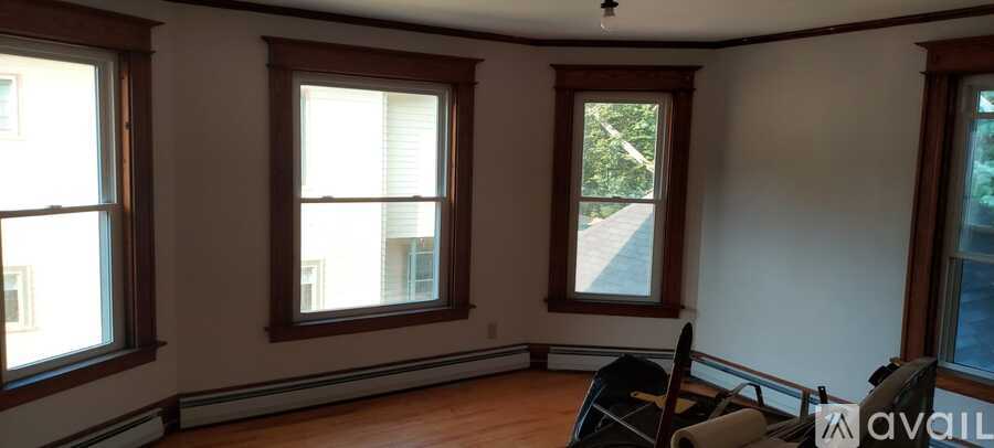 A room with three windows and a sign that says "available".