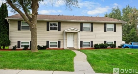 A beige house with a white door and windows.
